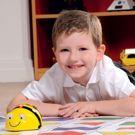 Child programming Bee-Bot robot for directional language and coding skills